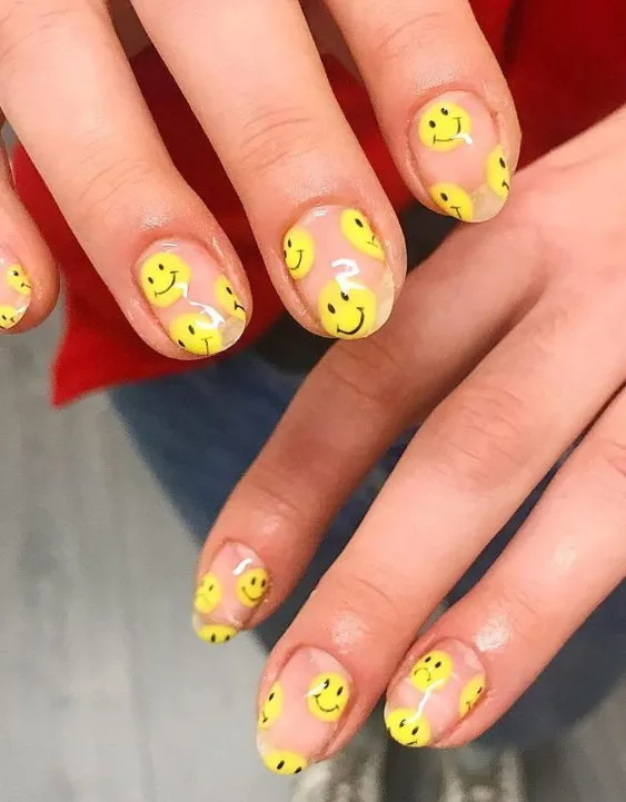 Clear nails with neon yellow smiley face designs