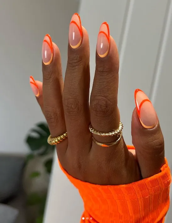 Neon orange nails with negative space designs