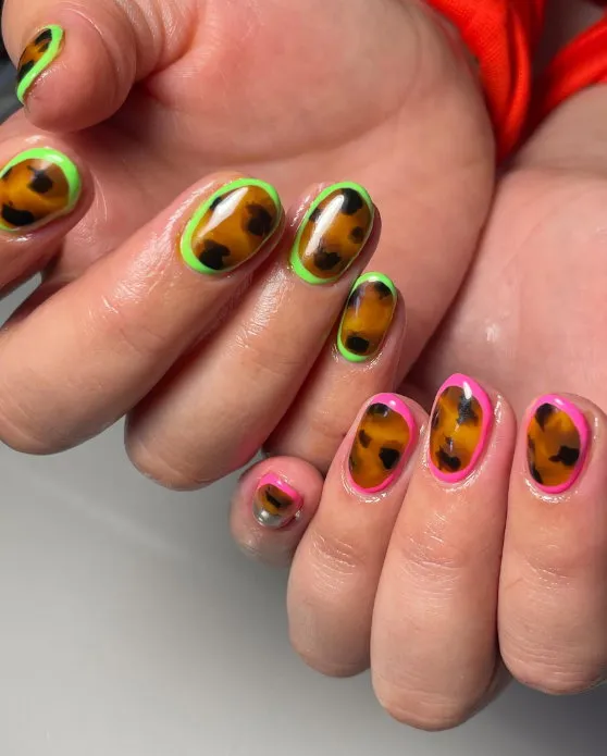 Short round tortoiseshell nails with neon green and pink details